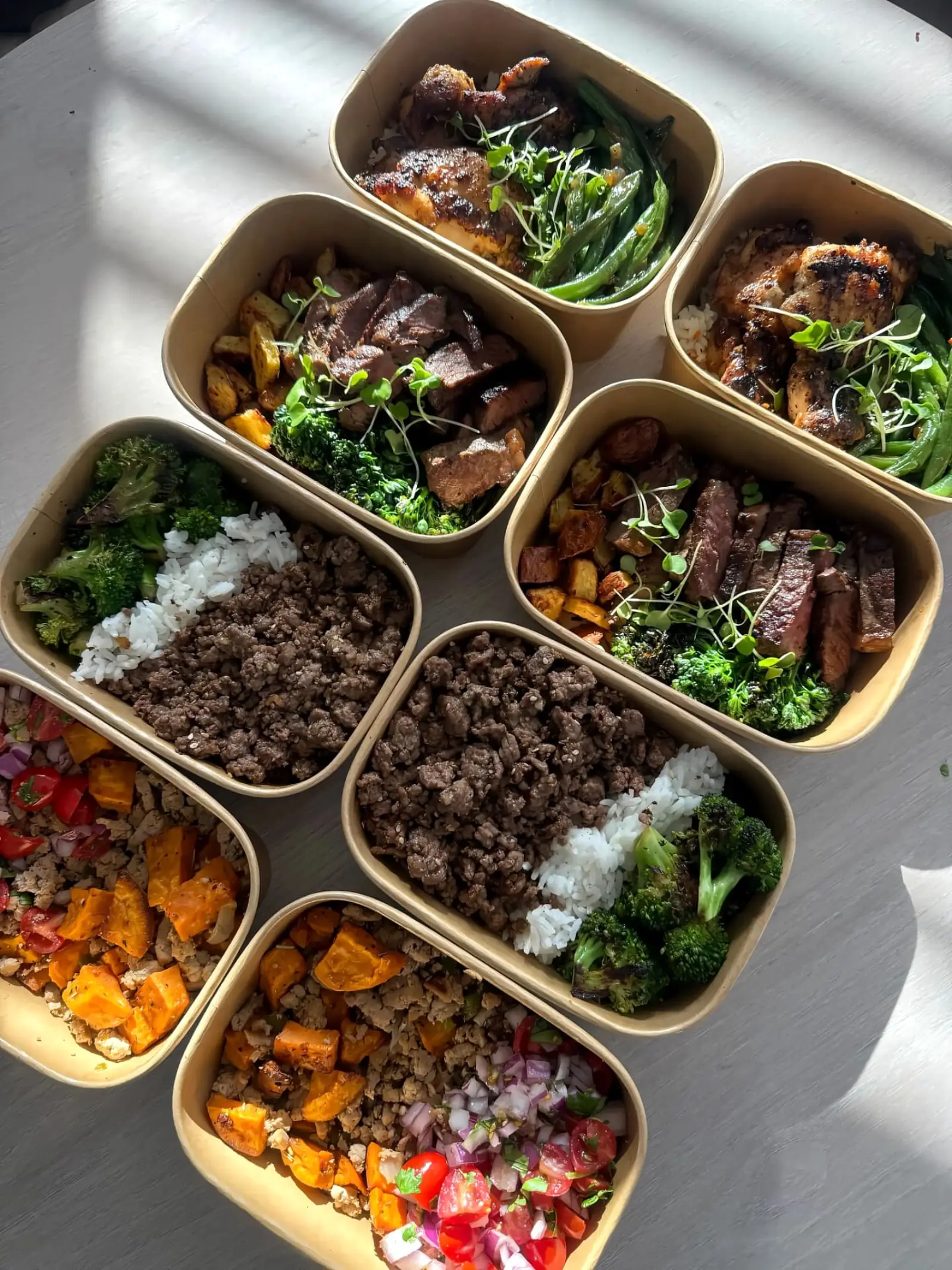 Meal-prep containers with beef, chicken, rice and vegetables